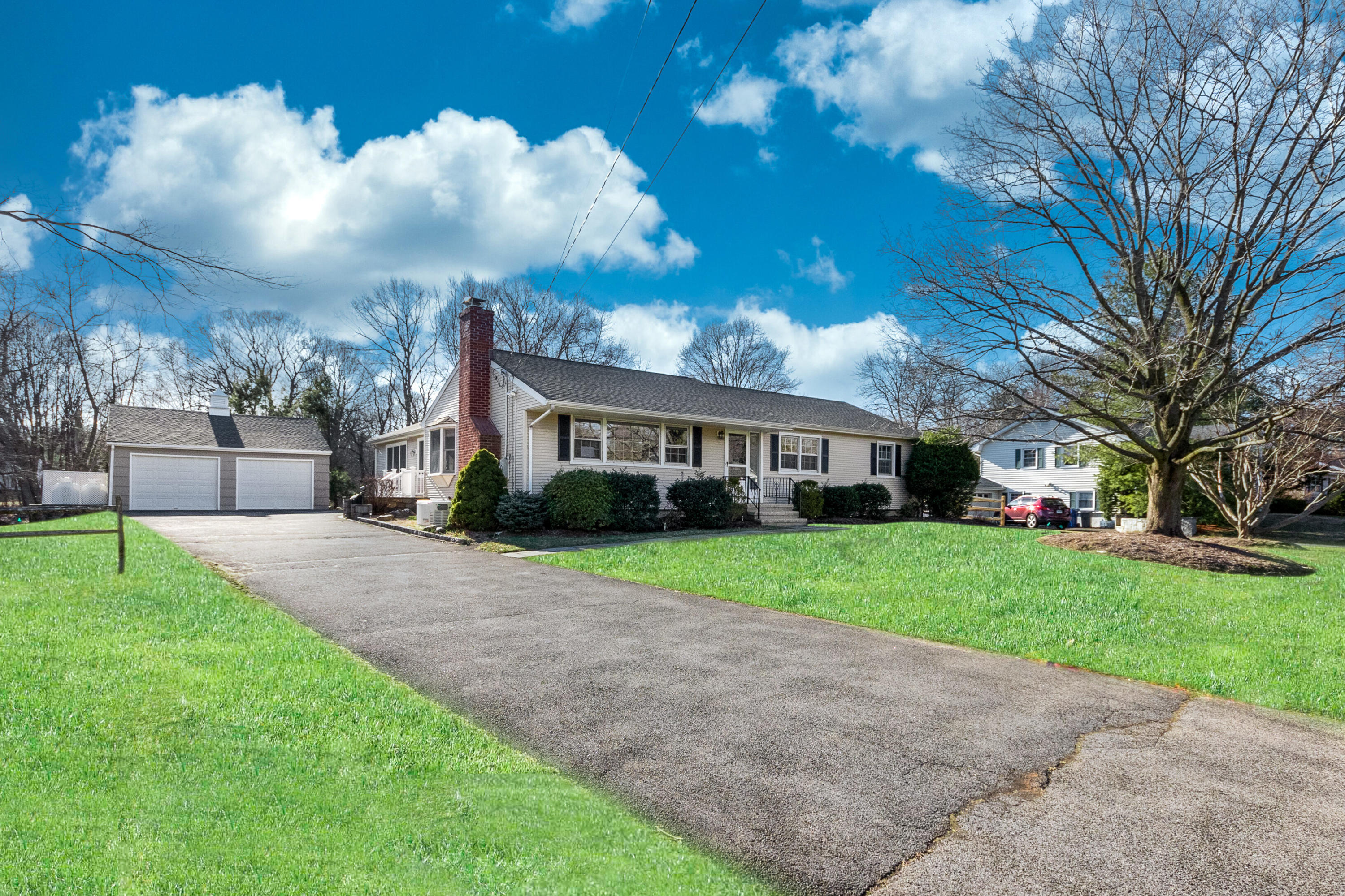 a front view of a house with a garden and trees