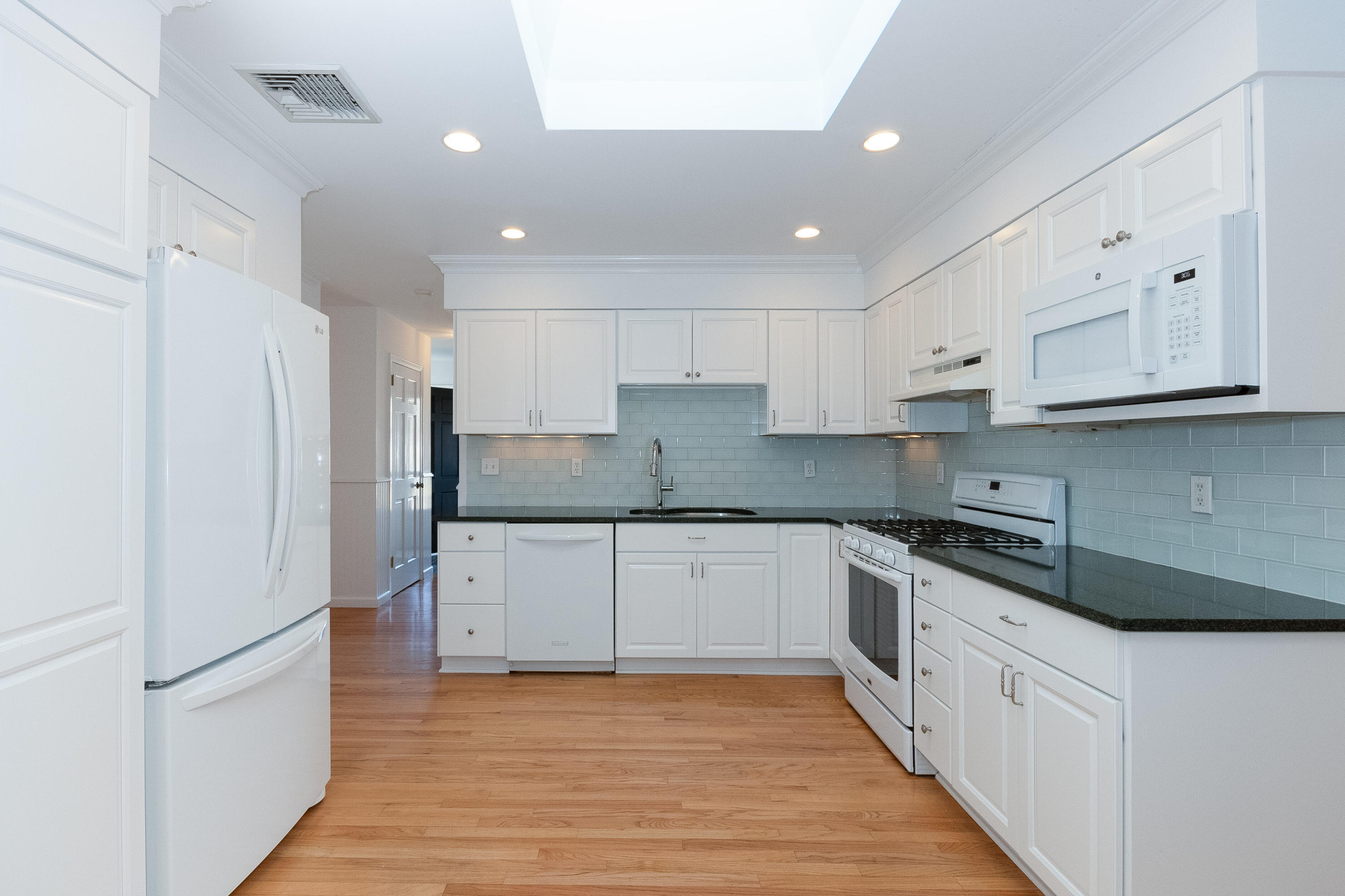 11 Cottontail Road Norwalk, CT 06854 - Photo 13 of 47 a large kitchen with stainless steel appliances granite countertop a stove a refrigerator and white cabinets with wooden floors