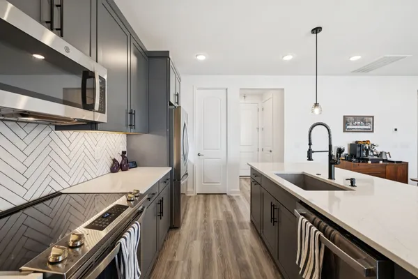 a kitchen with counter top space a sink and appliances