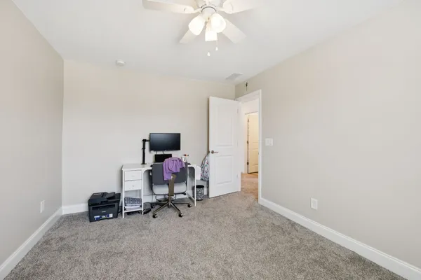 a view of a workspace with furniture and a window