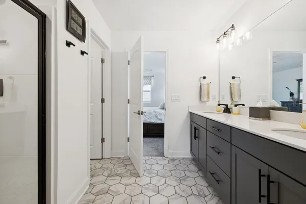 a spacious bathroom with a double vanity sink a mirror and a shower