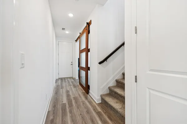 a view of a hallway with wooden floor and staircase