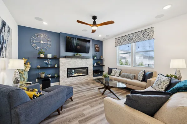 a living room with furniture a flat screen tv and a fireplace