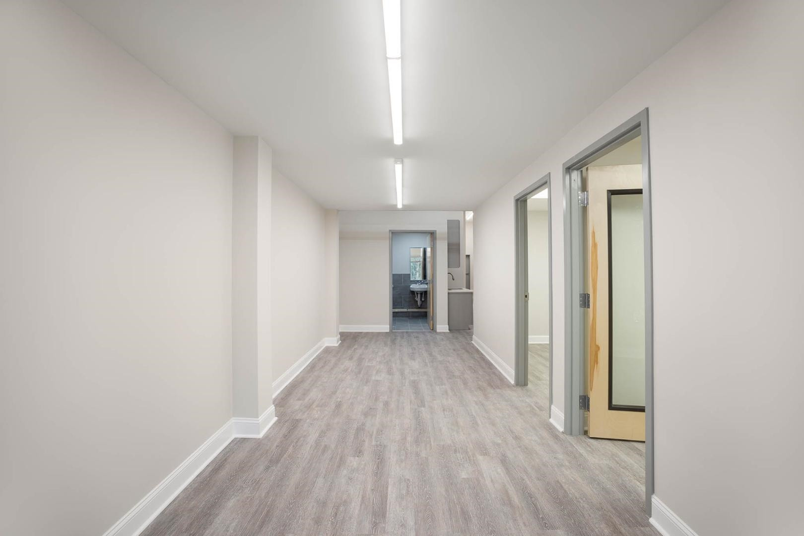5621 Departure Drive, Unit 101 Raleigh, NC 27616 - Photo 4 of 17 a view of a hallway with wooden floor and a bathroom