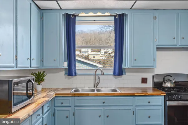 a kitchen with stainless steel appliances white cabinets and a window