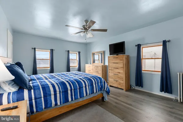 a bedroom with a large bed a flat tv screen and dresser