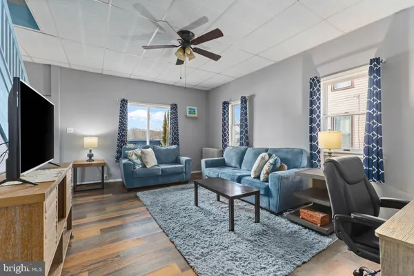 a living room with furniture a rug and a flat screen tv
