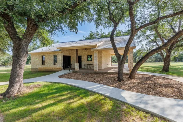 a view of a house with backyard and a tree