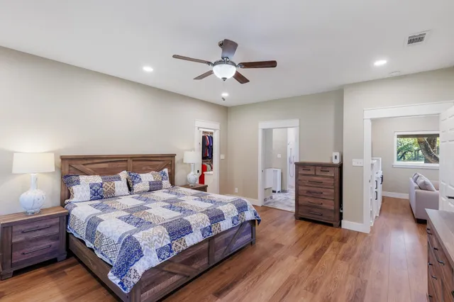 a bedroom with bed cabinets and wooden floor