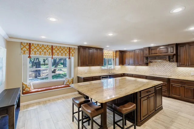 a kitchen with stainless steel appliances granite countertop a stove top oven a sink and a granite counter tops