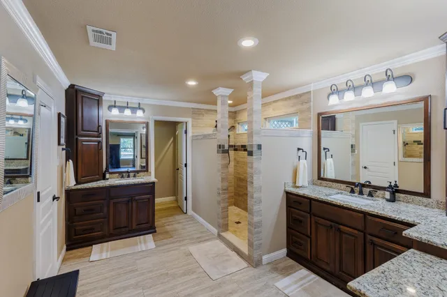 a spacious bathroom with a granite countertop sink mirror and shower