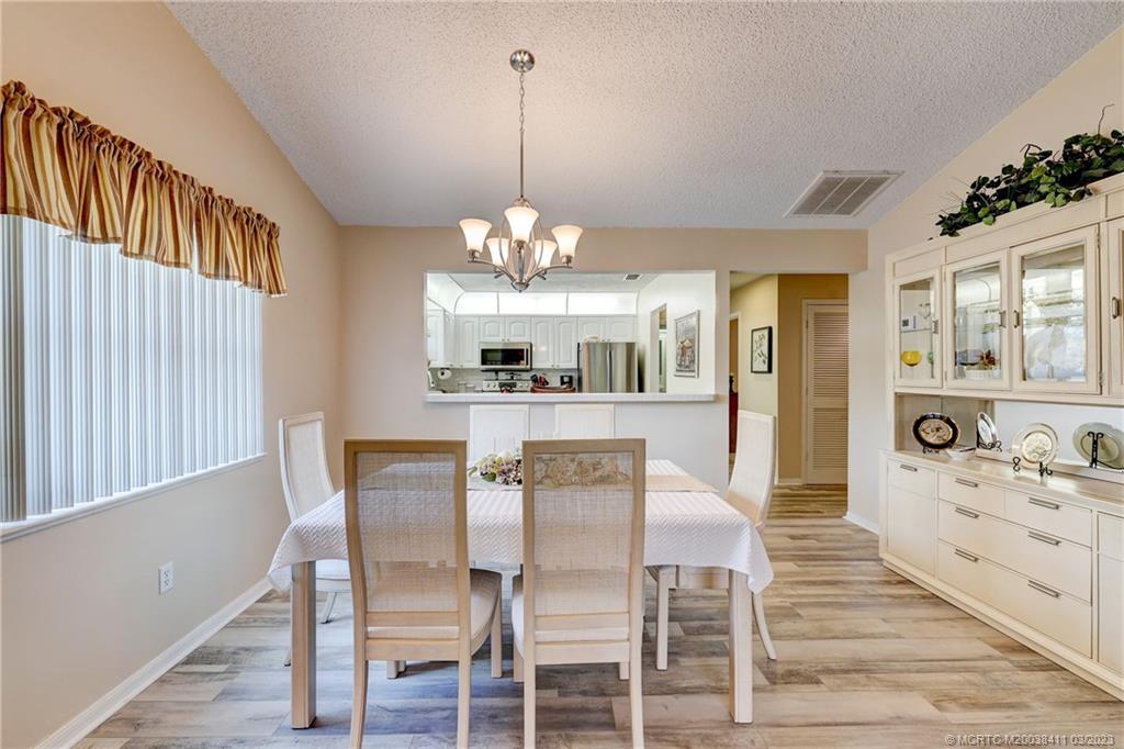 1881 Southwest Palm City Road, Unit H102 Stuart, FL 34994 - Photo 2 of 30 a view of a dining room with furniture and chandelier