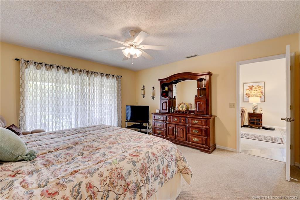 1881 Southwest Palm City Road, Unit H102 Stuart, FL 34994 - Photo 10 of 30 a bedroom with a large bed and a chandelier