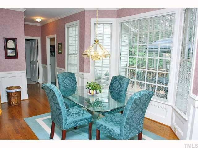7016 Spring Ridge Road Cary, NC 27518 - Photo 4 of 9 The large breakfast area has hardwood flooring, crown molding & wainscotting, large bay window overlooking the deck and private fenced backyard.