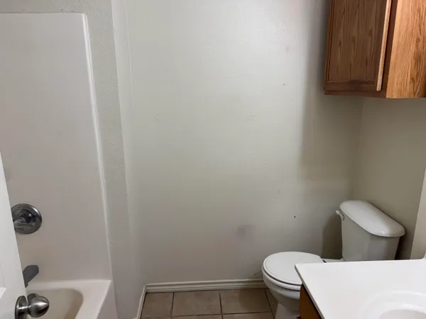 a white toilet sitting next to a white sink and vanity