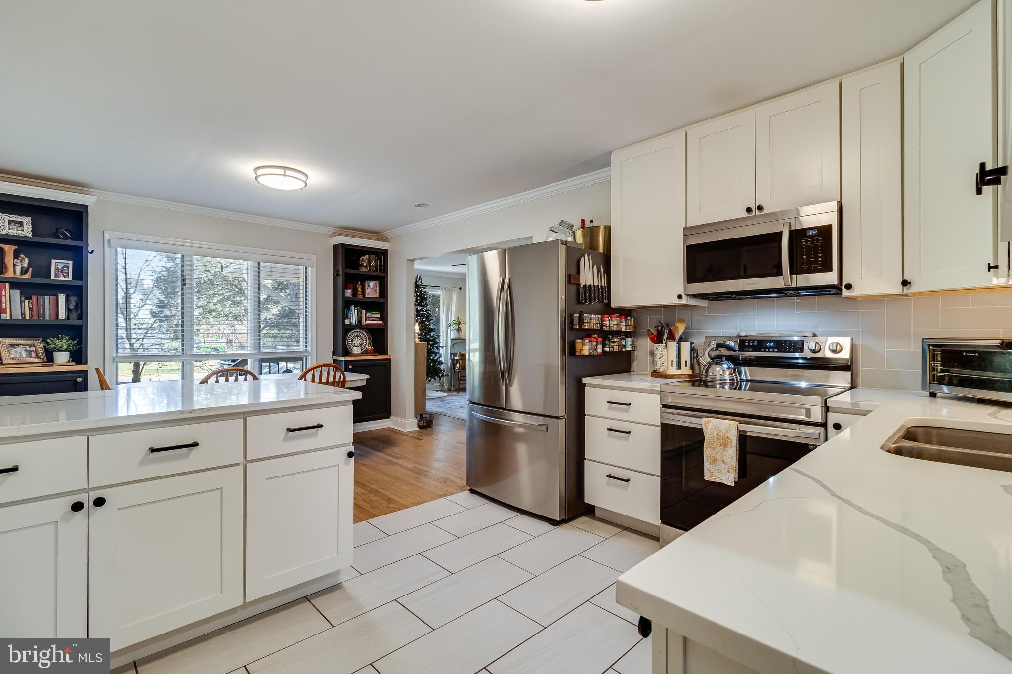 40905 Spring House Lane Leonardtown, MD 20650 - Photo 11 of 50 a kitchen with stainless steel appliances kitchen island granite countertop a refrigerator a stove a sink and white cabinets with wooden floor