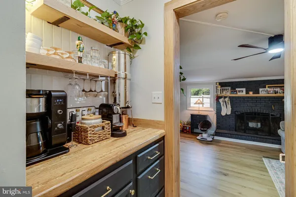 a kitchen with stainless steel appliances granite countertop a stove refrigerator and a fireplace with the bookshelf