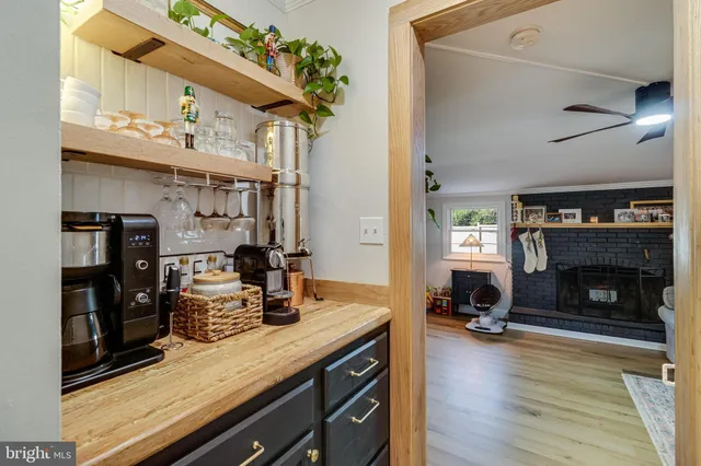 a kitchen with stainless steel appliances granite countertop a stove refrigerator and a fireplace with the bookshelf