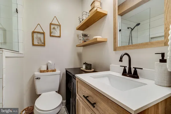 a bathroom with a sink a toilet and a mirror