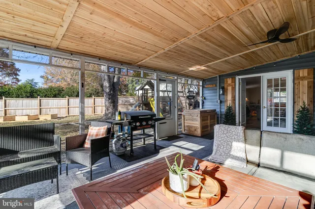 a living room with furniture a wooden floor and next to a window