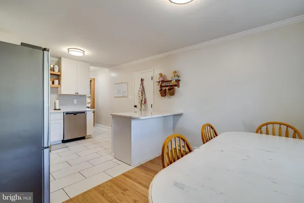 a view of a kitchen area with furniture and wooden floor