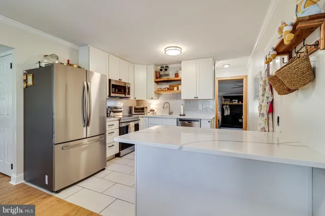 a kitchen with stainless steel appliances granite countertop a refrigerator and a stove
