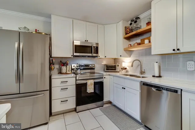 a kitchen with cabinets stainless steel appliances and a counter space
