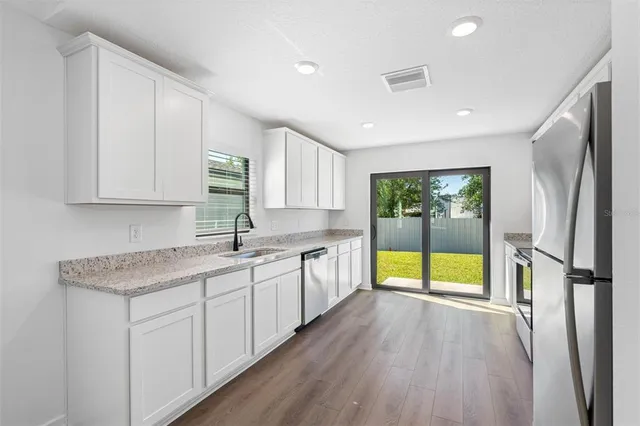 a kitchen with a sink a refrigerator and window