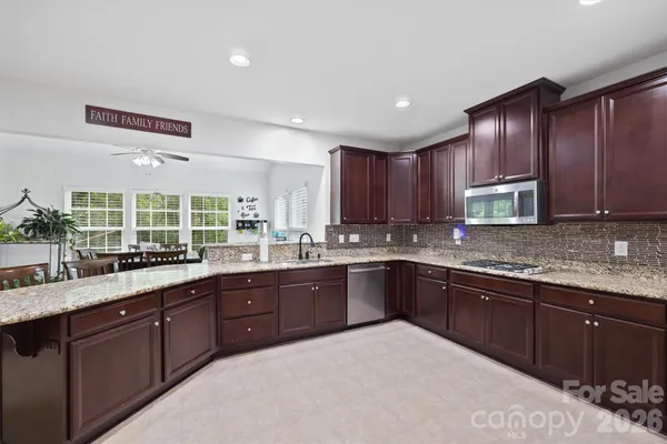 a large kitchen with wooden cabinets and sink