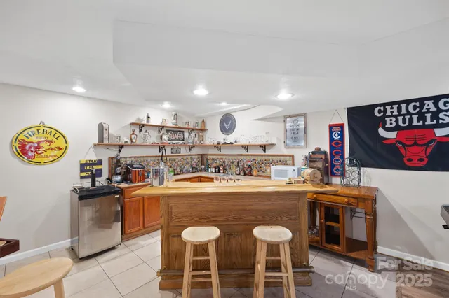 a kitchen with stainless steel appliances granite countertop a stove top oven a sink a dining table and chairs with wooden floor