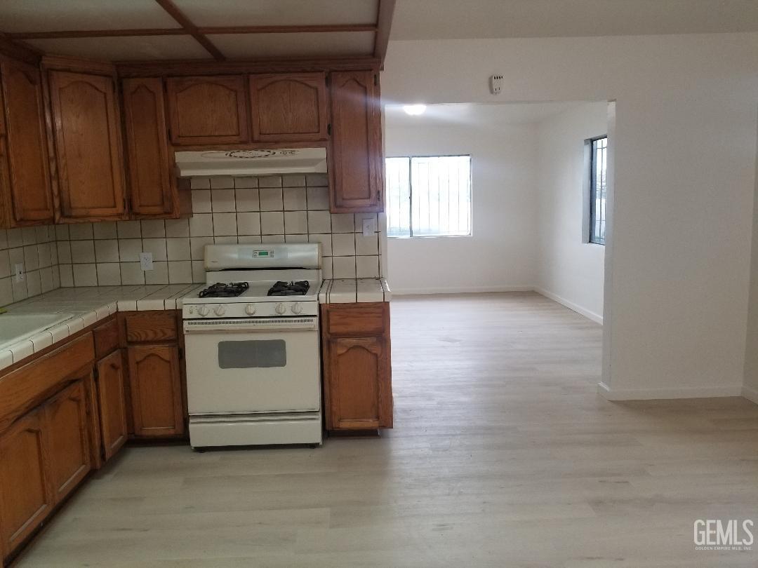 Undisclosed Address Delano, CA 93215 - Photo 5 of 8 a kitchen with a stove white cabinets and white appliances