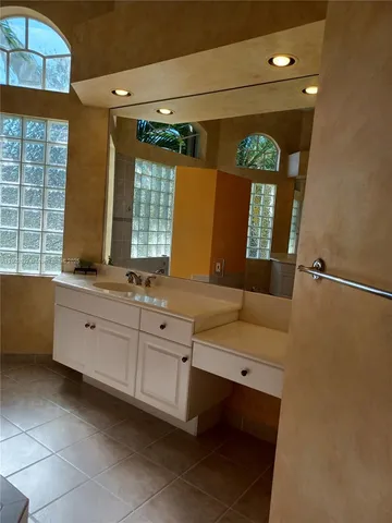 a bathroom with a double vanity sink mirror and bathtub