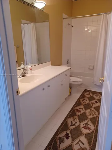 a bathroom with a double vanity sink a toilet and a shower