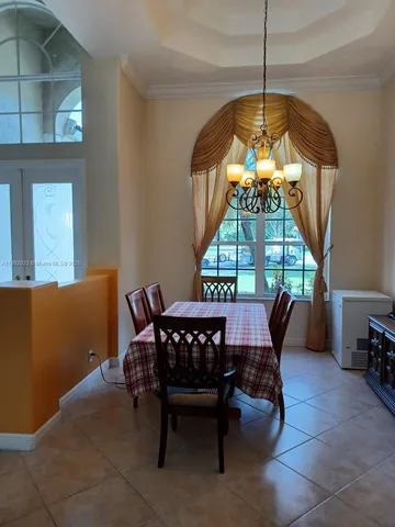 a view of a dining room with furniture and a chandelier