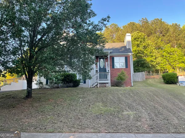 a view of a house with a tree in front of it