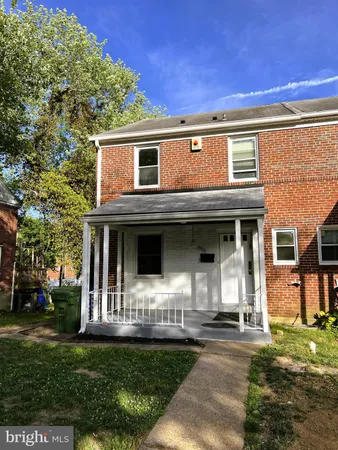 a view of a white house with large windows and a yard