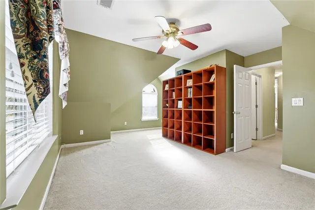 a view of empty room with windows and ceiling fan
