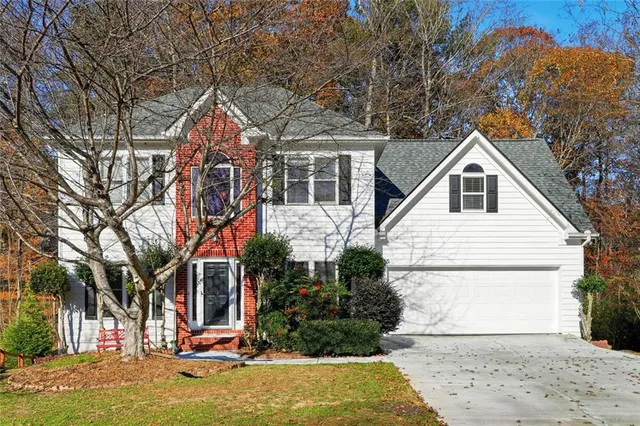 a view of a white house with a big yard and large trees
