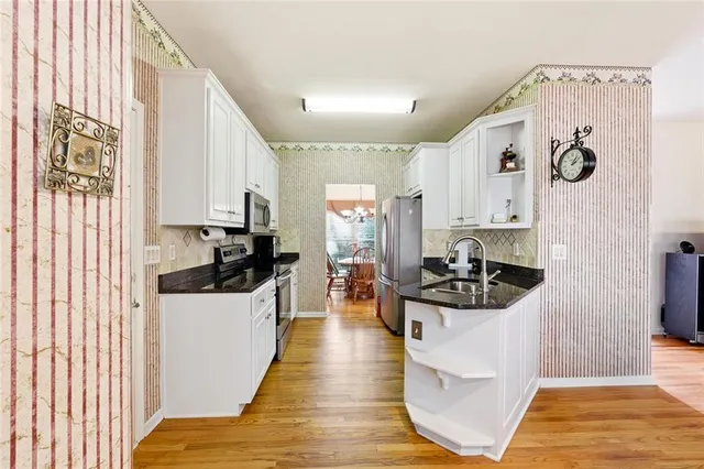 a kitchen with a sink and wooden floor
