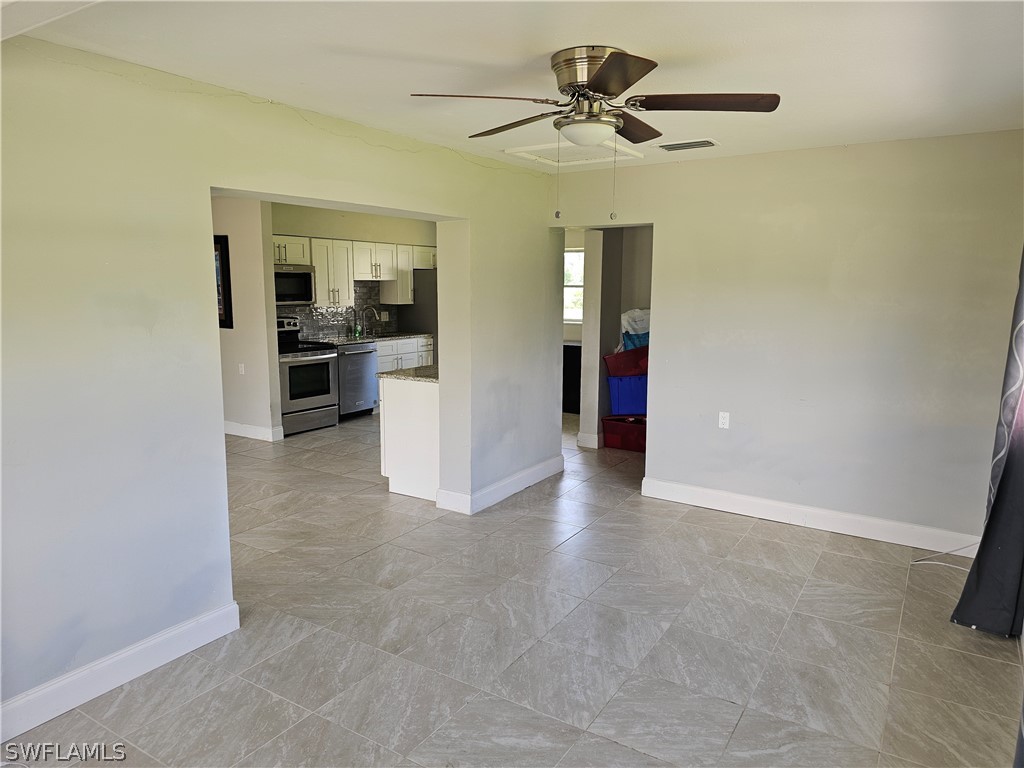 200 Oregon Road West Lehigh Acres, FL 33936 - Photo 9 of 18 a view of a hallway with a kitchen