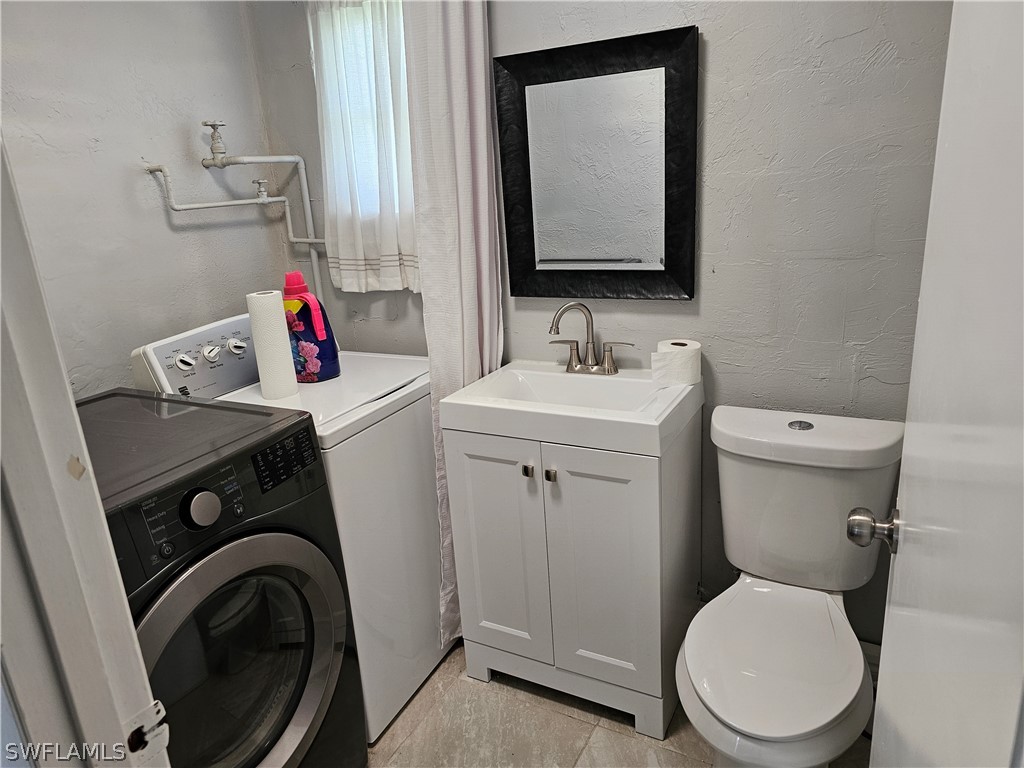200 Oregon Road West Lehigh Acres, FL 33936 - Photo 10 of 18 a bathroom with a toilet sink and mirror
