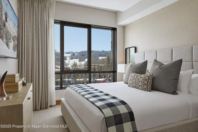 a bedroom with a balcony a bed and a large window