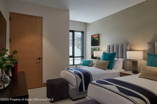 a bedroom with two beds and a potted plant