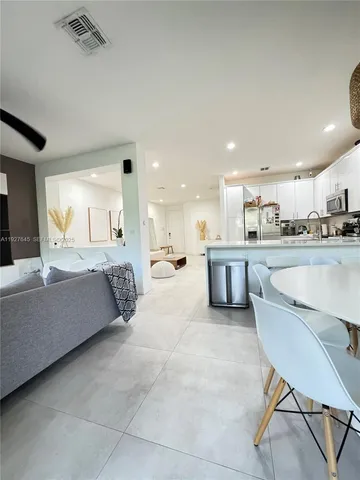 a living room with furniture and a view of kitchen