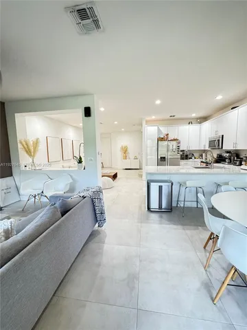 a living room with furniture and kitchen view