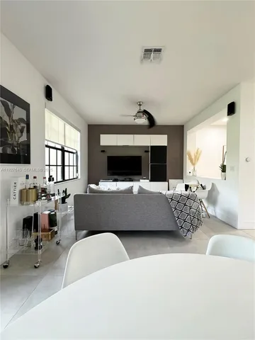 a living room with kitchen island stainless steel appliances wooden floor and view living room