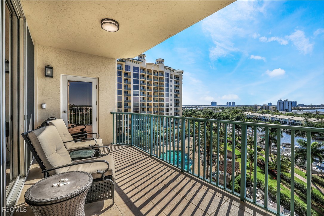 a balcony with wooden floor table and chairs