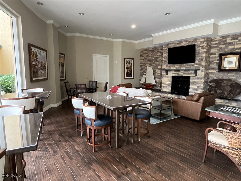 3426 Hancock Bridge Parkway, Unit 704 North Fort Myers, FL 33903 - Photo 32 of 37 a living room with furniture a fireplace and a flat screen tv