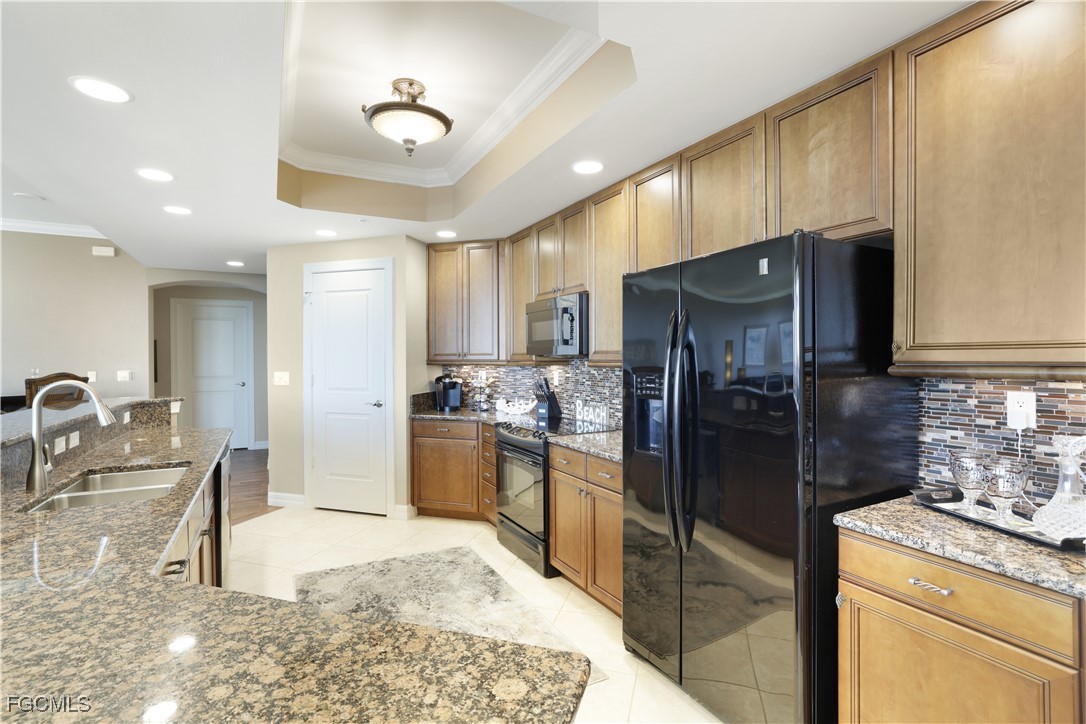 3426 Hancock Bridge Parkway, Unit 704 North Fort Myers, FL 33903 - Photo 9 of 37 a kitchen with stainless steel appliances kitchen island granite countertop a refrigerator a stove and a sink with wooden floor