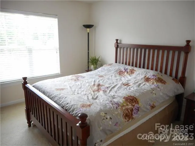 a bed sitting in a bedroom next to a window